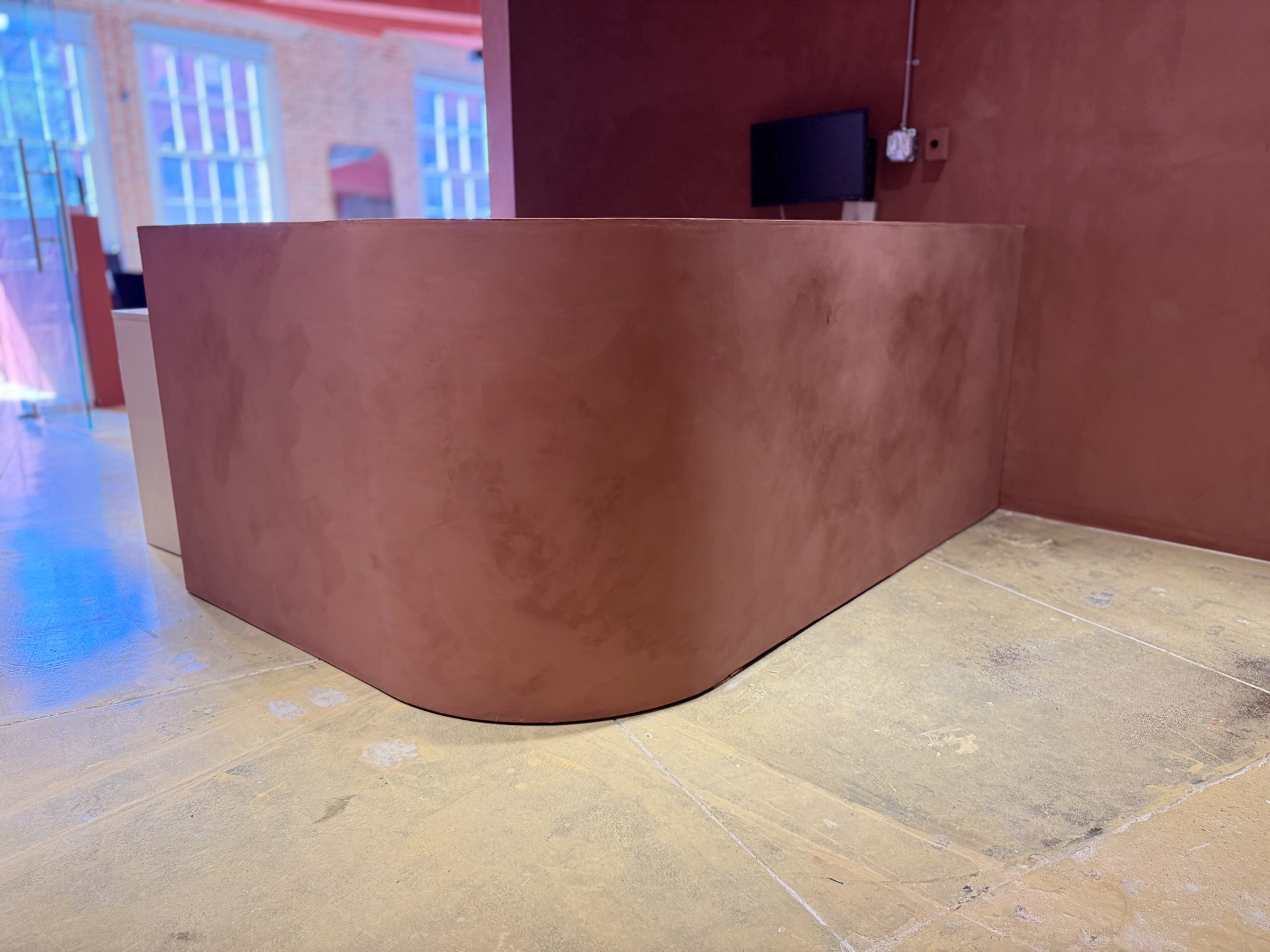 Terracotta limewash reception desk in a New York showroom